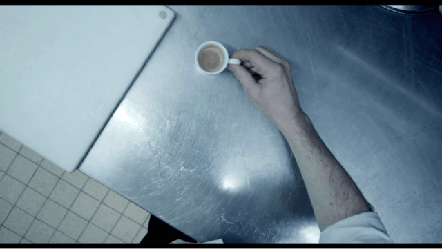 Man's hand holding cup of coffee from his point-of-view