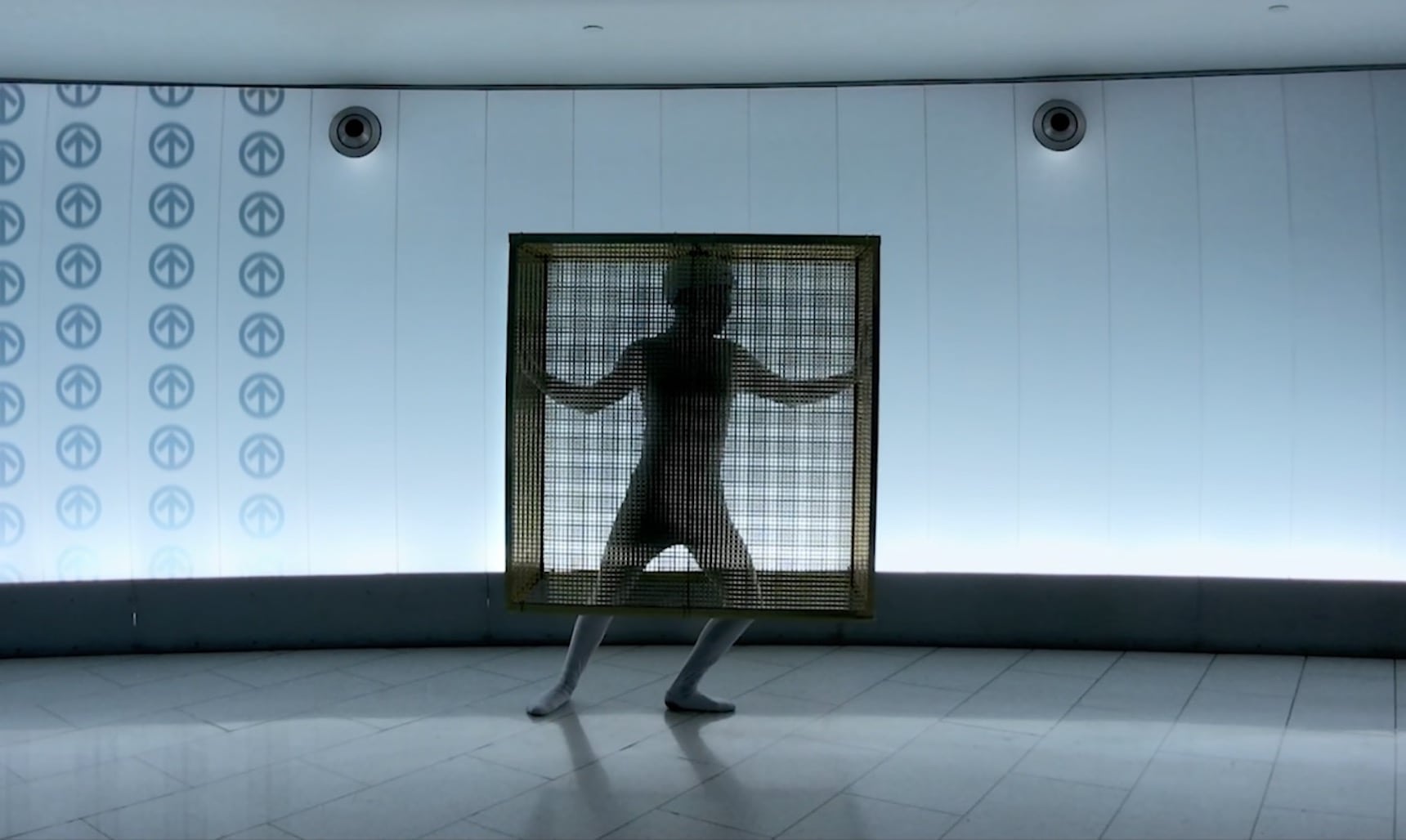 A person dancing in a golden cube cage in Montreal subway