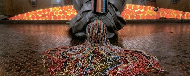 Person bows down wearing a colourful costume