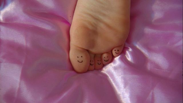 Feet on a pink satin duvet 