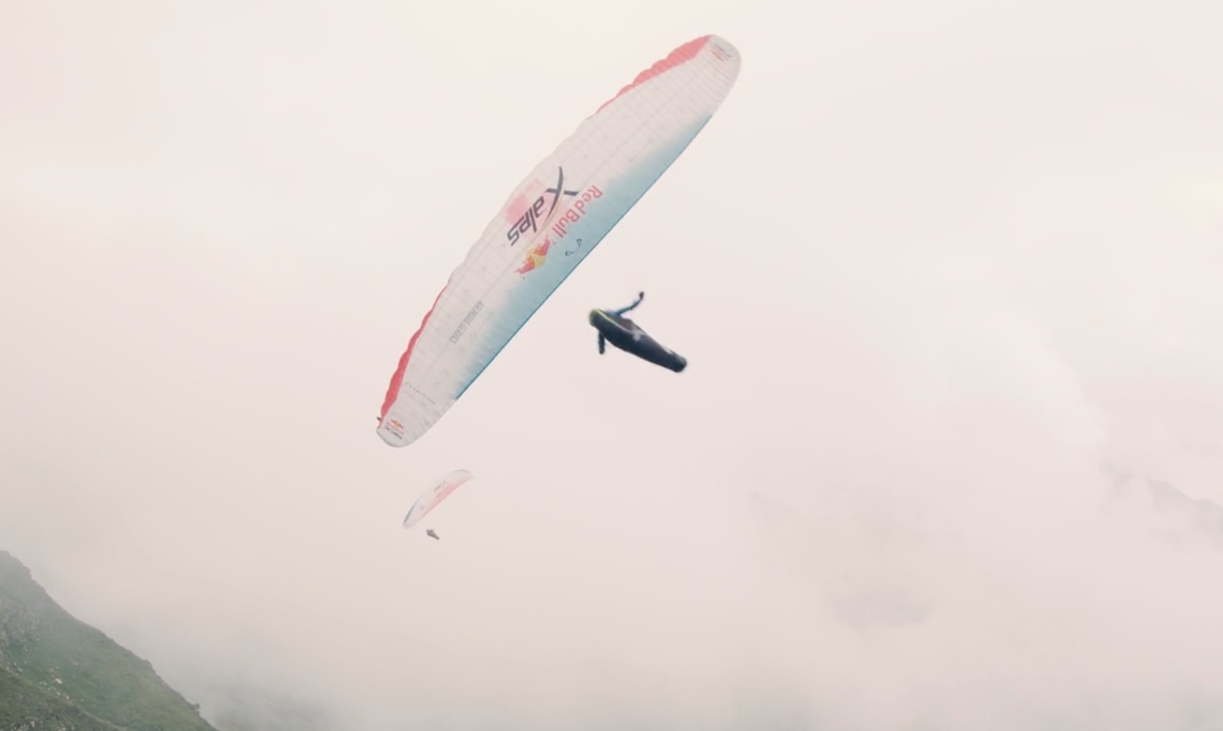A paraglider flying through the misty sky