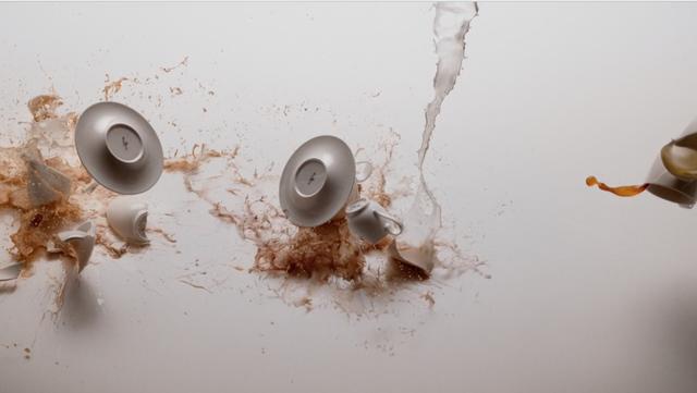 Coffee cups flying and spilling out on a white tablecloth