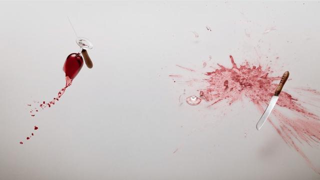 red wine and a knife levitating on a white background