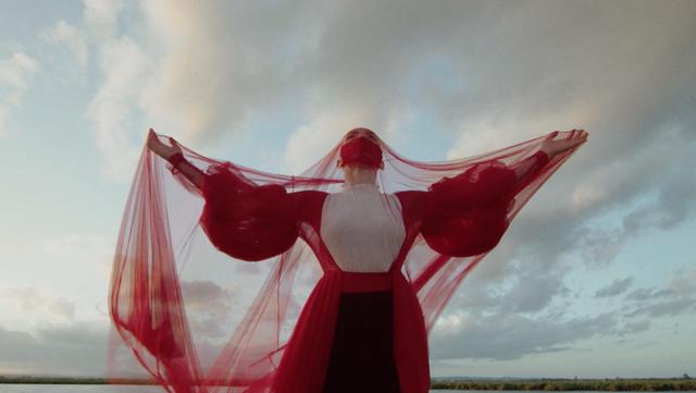 Dancer and choreographer Jessica Ruso in red dress and open arms